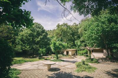 Cour intérieure pavée entourée de murs en pierre, avec des plantes grimpantes et des fenêtres sur une façade.