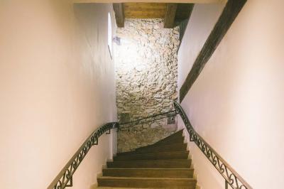 Cour intérieure pavée entourée de murs en pierre, avec des plantes grimpantes et des fenêtres sur une façade.