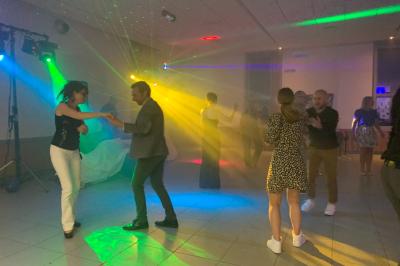 Façade d'un bâtiment en briques avec grandes fenêtres, porte ouverte et équipements audio installés à l'extérieur.