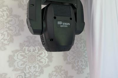 Façade d'un bâtiment en briques avec grandes fenêtres, porte ouverte et équipements audio installés à l'extérieur.