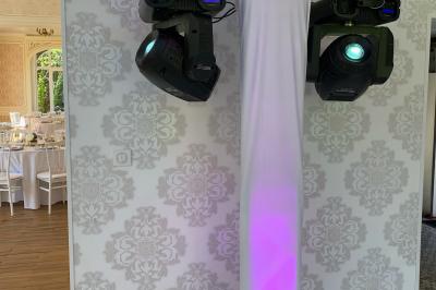 Façade d'un bâtiment en briques avec grandes fenêtres, porte ouverte et équipements audio installés à l'extérieur.