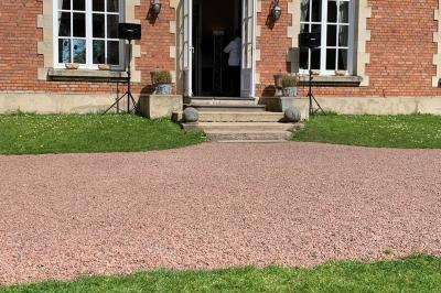 Façade d'un bâtiment en briques avec grandes fenêtres, porte ouverte et équipements audio installés à l'extérieur.