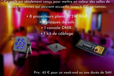 Façade d'un bâtiment en briques avec grandes fenêtres, porte ouverte et équipements audio installés à l'extérieur.