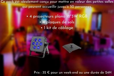 Façade d'un bâtiment en briques avec grandes fenêtres, porte ouverte et équipements audio installés à l'extérieur.