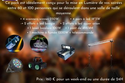 Façade d'un bâtiment en briques avec grandes fenêtres, porte ouverte et équipements audio installés à l'extérieur.