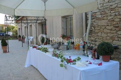 Gâteau de mariage à trois étages décoré de fleurs blanches, feuillages et roses crème au sommet.
