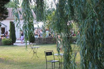 Gâteau de mariage à trois étages décoré de fleurs blanches, feuillages et roses crème au sommet.