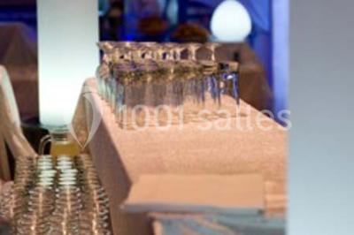 Gâteau de mariage à trois étages décoré de fleurs blanches, feuillages et roses crème au sommet.