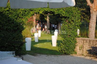 Gâteau de mariage à trois étages décoré de fleurs blanches, feuillages et roses crème au sommet.