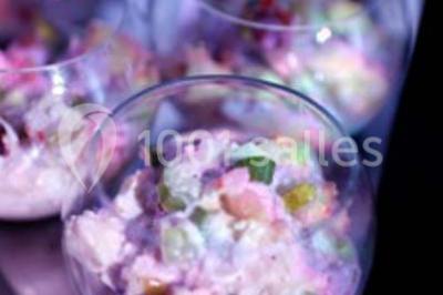 Gâteau de mariage à trois étages décoré de fleurs blanches, feuillages et roses crème au sommet.
