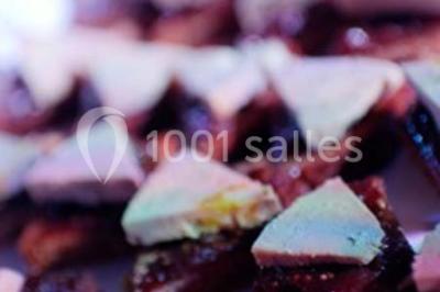 Gâteau de mariage à trois étages décoré de fleurs blanches, feuillages et roses crème au sommet.