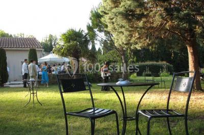 Gâteau de mariage à trois étages décoré de fleurs blanches, feuillages et roses crème au sommet.