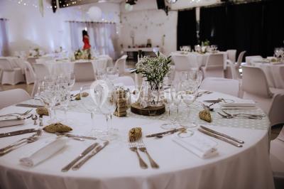 Gâteau de mariage à trois étages décoré de fleurs blanches, feuillages et roses crème au sommet.