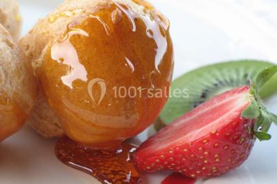 Gâteau de mariage à trois étages décoré de fleurs blanches, feuillages et roses crème au sommet.