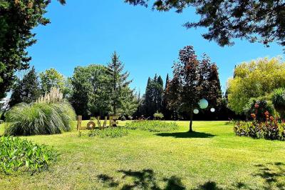Gâteau de mariage à trois étages décoré de fleurs blanches, feuillages et roses crème au sommet.