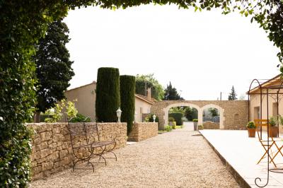Gâteau de mariage à trois étages décoré de fleurs blanches, feuillages et roses crème au sommet.