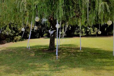 Gâteau de mariage à trois étages décoré de fleurs blanches, feuillages et roses crème au sommet.