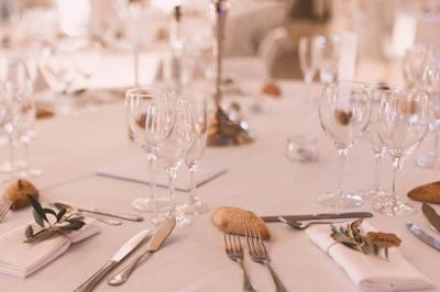 Gâteau de mariage à trois étages décoré de fleurs blanches, feuillages et roses crème au sommet.