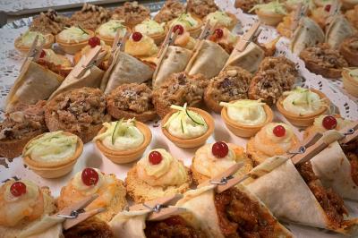 Gâteau de mariage à trois étages décoré de fleurs blanches, feuillages et roses crème au sommet.