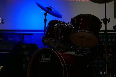 Lit avec oreillers blancs, lampe de chevet allumée et miroir reflétant une penderie et des portes dans une chambre lumineuse.