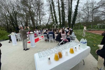 Table élégamment dressée avec vaisselle raffinée, centre de table floral et décoration lumineuse en arrière-plan.