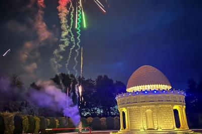 Table élégamment dressée avec vaisselle raffinée, centre de table floral et décoration lumineuse en arrière-plan.