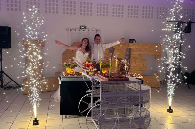 Table élégamment dressée avec vaisselle raffinée, centre de table floral et décoration lumineuse en arrière-plan.