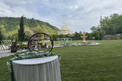 Table élégamment dressée avec vaisselle raffinée, centre de table floral et décoration lumineuse en arrière-plan.