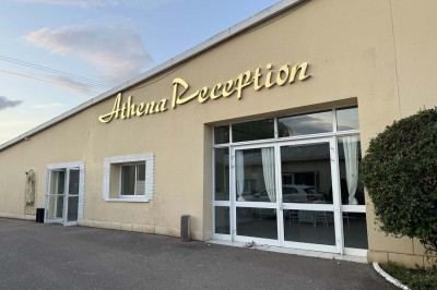 Table élégamment dressée avec vaisselle raffinée, centre de table floral et décoration lumineuse en arrière-plan.