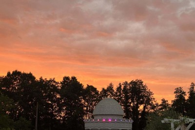 Table élégamment dressée avec vaisselle raffinée, centre de table floral et décoration lumineuse en arrière-plan.