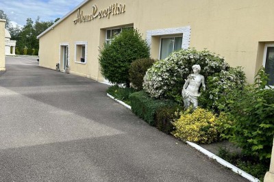 Table élégamment dressée avec vaisselle raffinée, centre de table floral et décoration lumineuse en arrière-plan.