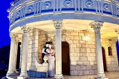 Table élégamment dressée avec vaisselle raffinée, centre de table floral et décoration lumineuse en arrière-plan.