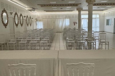 Table élégamment dressée avec vaisselle raffinée, centre de table floral et décoration lumineuse en arrière-plan.