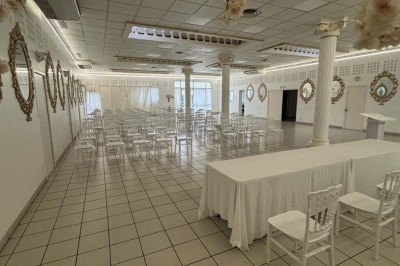 Table élégamment dressée avec vaisselle raffinée, centre de table floral et décoration lumineuse en arrière-plan.