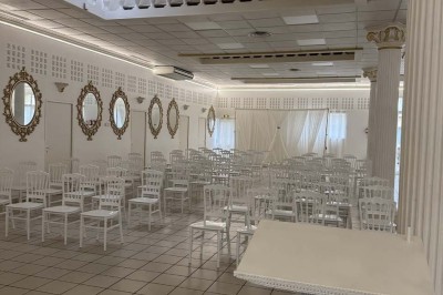 Table élégamment dressée avec vaisselle raffinée, centre de table floral et décoration lumineuse en arrière-plan.