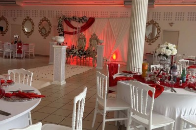 Table élégamment dressée avec vaisselle raffinée, centre de table floral et décoration lumineuse en arrière-plan.