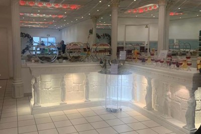 Table élégamment dressée avec vaisselle raffinée, centre de table floral et décoration lumineuse en arrière-plan.