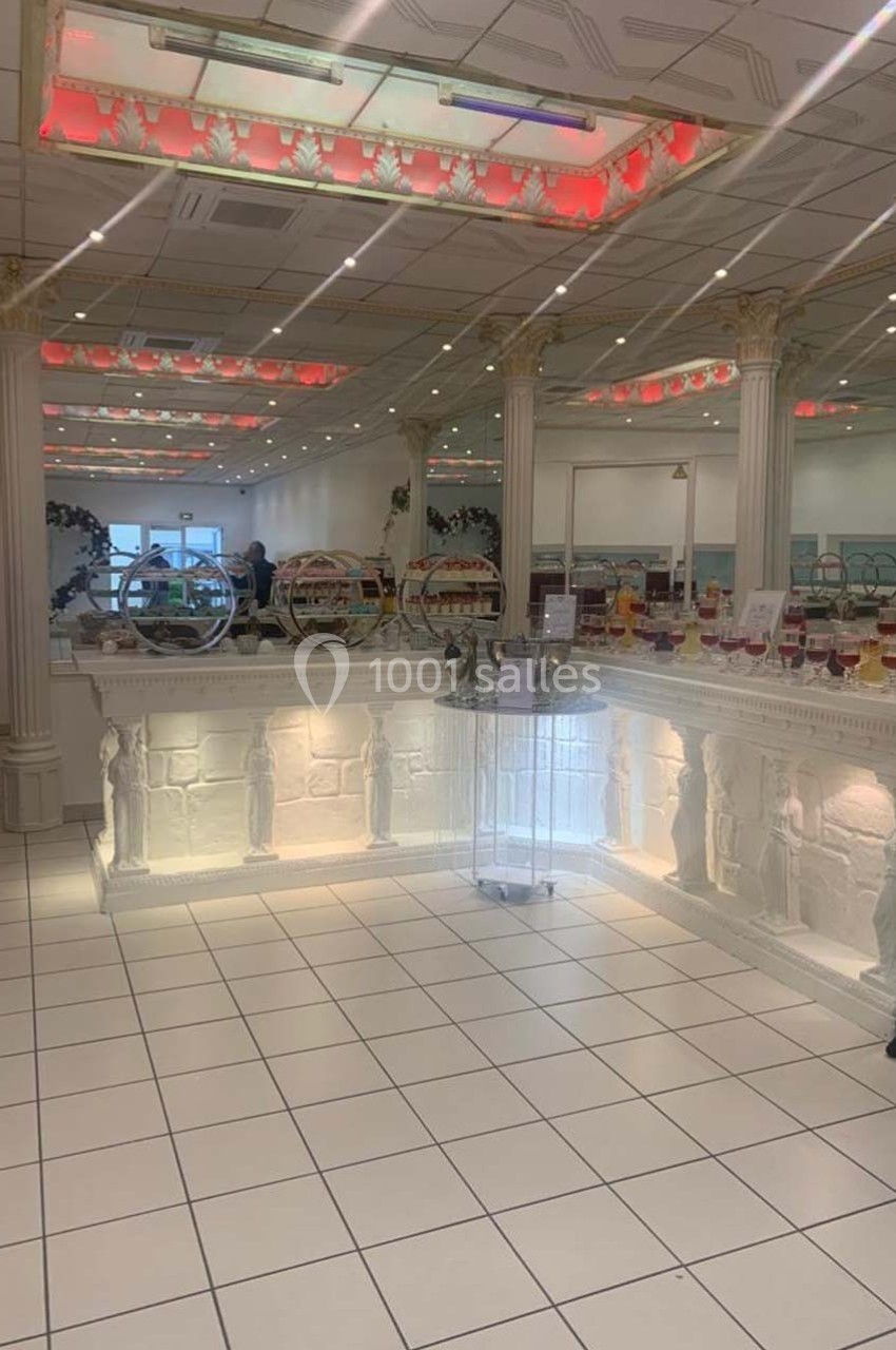 Intérieur d'une pâtisserie lumineuse avec un comptoir décoré de sculptures et des présentoirs garnis de desserts.