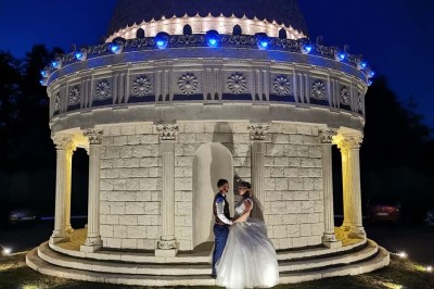 Table élégamment dressée avec vaisselle raffinée, centre de table floral et décoration lumineuse en arrière-plan.