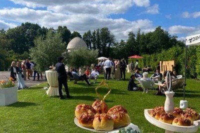 Table élégamment dressée avec vaisselle raffinée, centre de table floral et décoration lumineuse en arrière-plan.