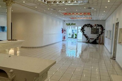 Table élégamment dressée avec vaisselle raffinée, centre de table floral et décoration lumineuse en arrière-plan.