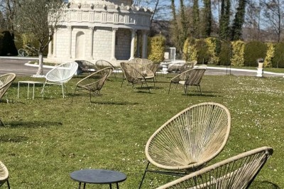 Table élégamment dressée avec vaisselle raffinée, centre de table floral et décoration lumineuse en arrière-plan.