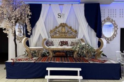 Table élégamment dressée avec vaisselle raffinée, centre de table floral et décoration lumineuse en arrière-plan.