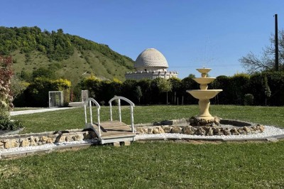 Table élégamment dressée avec vaisselle raffinée, centre de table floral et décoration lumineuse en arrière-plan.