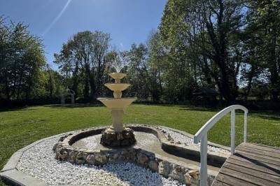 Table élégamment dressée avec vaisselle raffinée, centre de table floral et décoration lumineuse en arrière-plan.