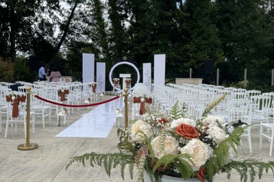 Table élégamment dressée avec vaisselle raffinée, centre de table floral et décoration lumineuse en arrière-plan.