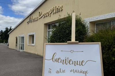 Table élégamment dressée avec vaisselle raffinée, centre de table floral et décoration lumineuse en arrière-plan.