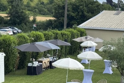 Table élégamment dressée avec vaisselle raffinée, centre de table floral et décoration lumineuse en arrière-plan.