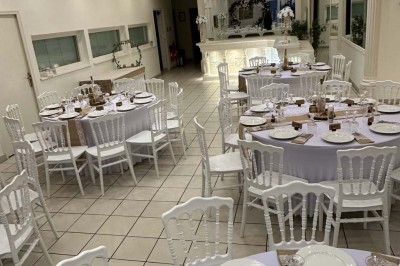 Table élégamment dressée avec vaisselle raffinée, centre de table floral et décoration lumineuse en arrière-plan.