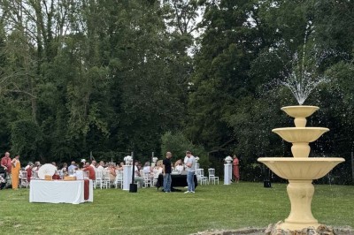 Table élégamment dressée avec vaisselle raffinée, centre de table floral et décoration lumineuse en arrière-plan.